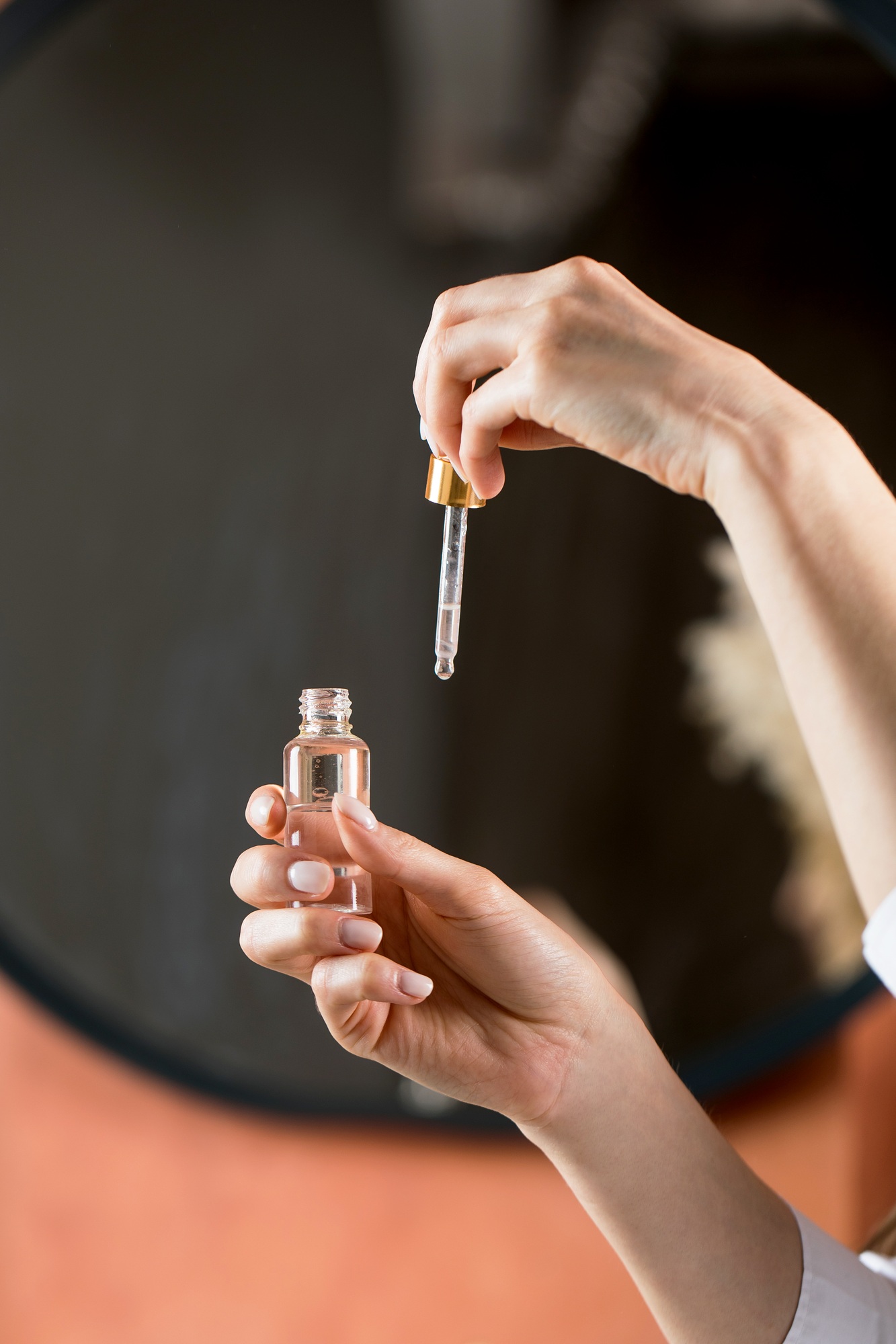 A woman holds a dropper and dropper with a drop of moisturizing serum for face